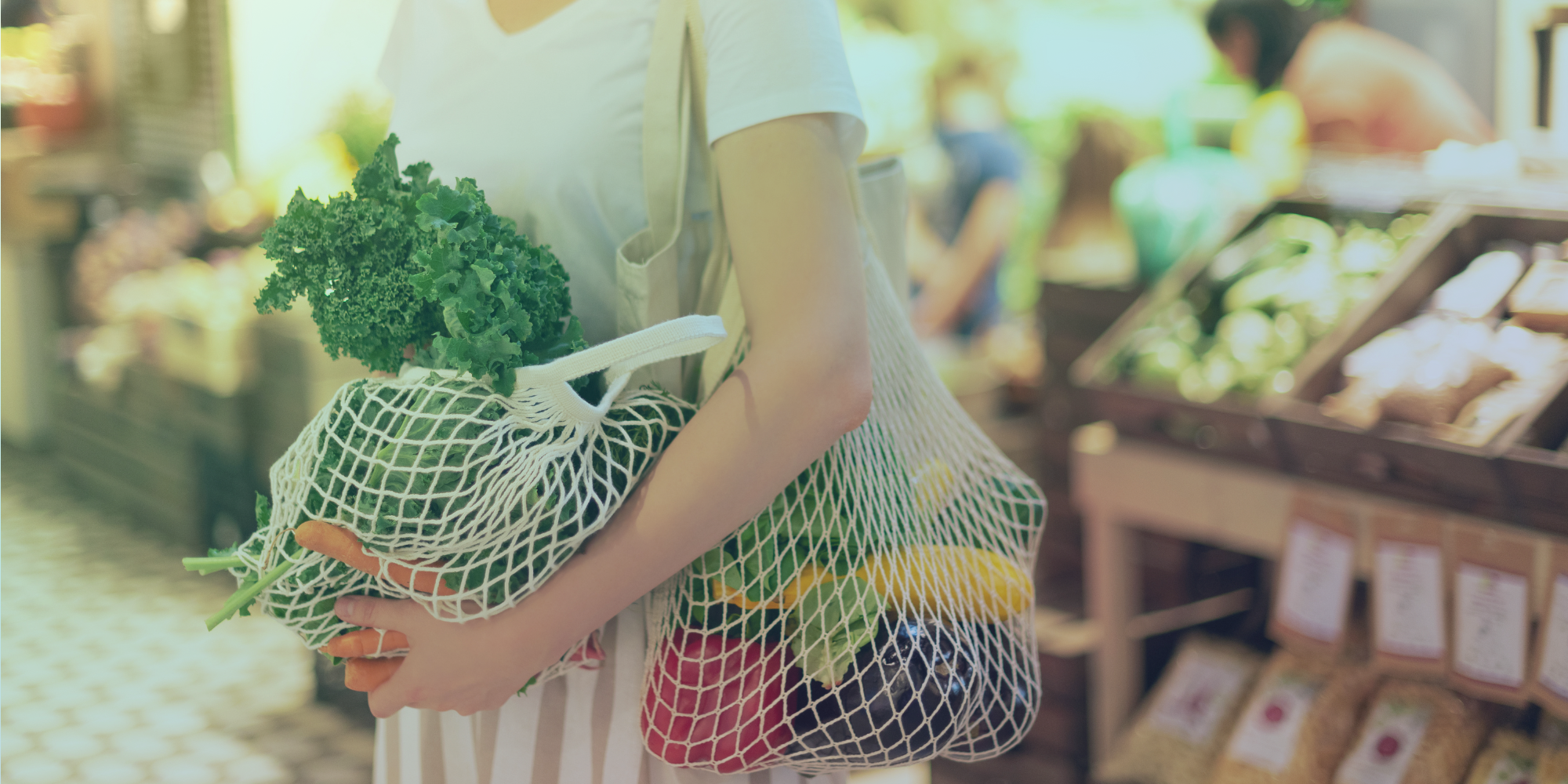 Woman carrying reusable shopping bags filled with vegetables