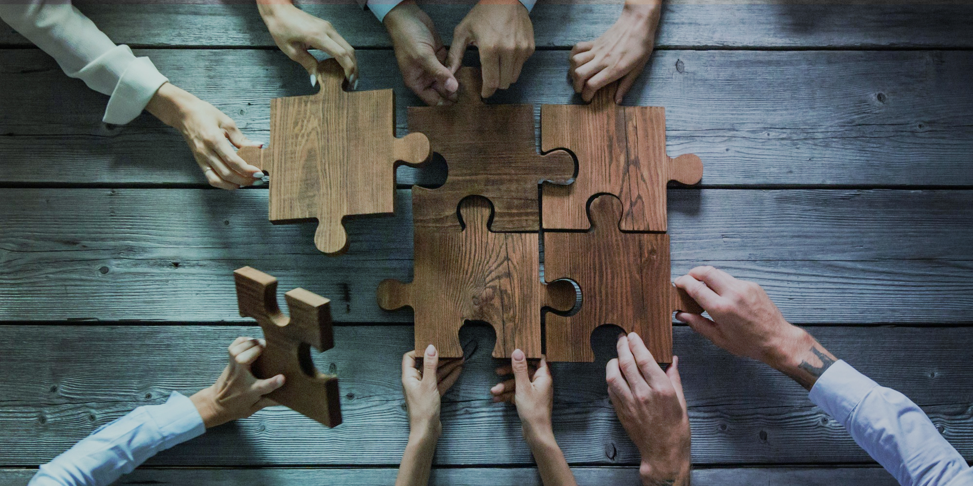 hands putting together puzzle pieces