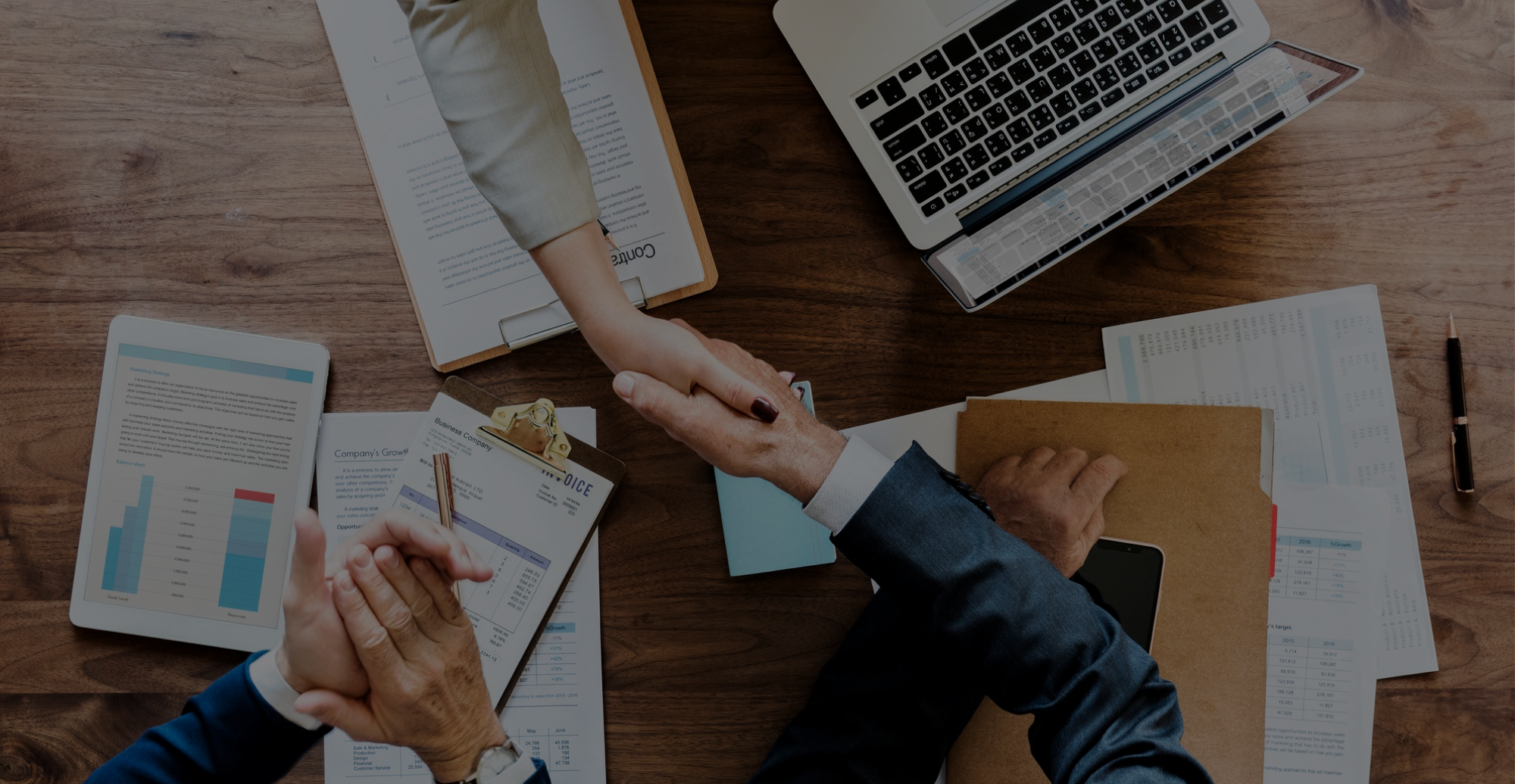 Banner image of two people in business suits shaking hands.